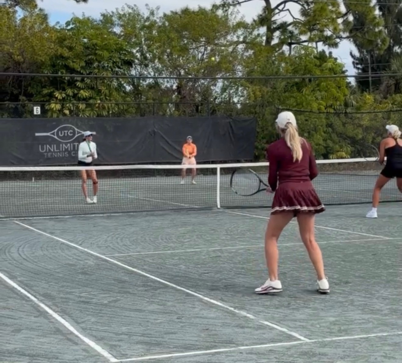 Two Unlimited Tennis Club members relaxing and talking after a clinic session in Fort Myers
